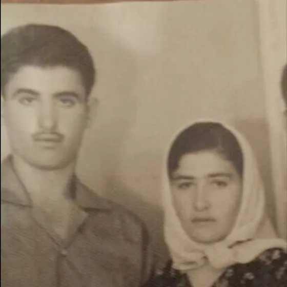Ein junges Paar – Ferdane und Ramazan Satır. Sie schauen in die Kamera und halten ihre Hände. Er trägt ein Hemd mit einem breiten Kragen, sie ein geblümtes Kleid und ein weißes Kopftuch.